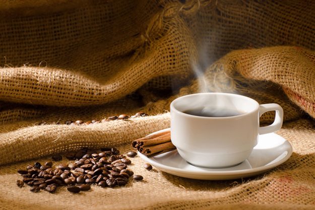 White coffee cup with smoke and coffee beans White coffee cup with smoke and coffee beans