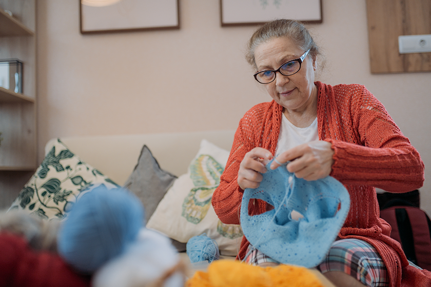 woman knits sitting couch
