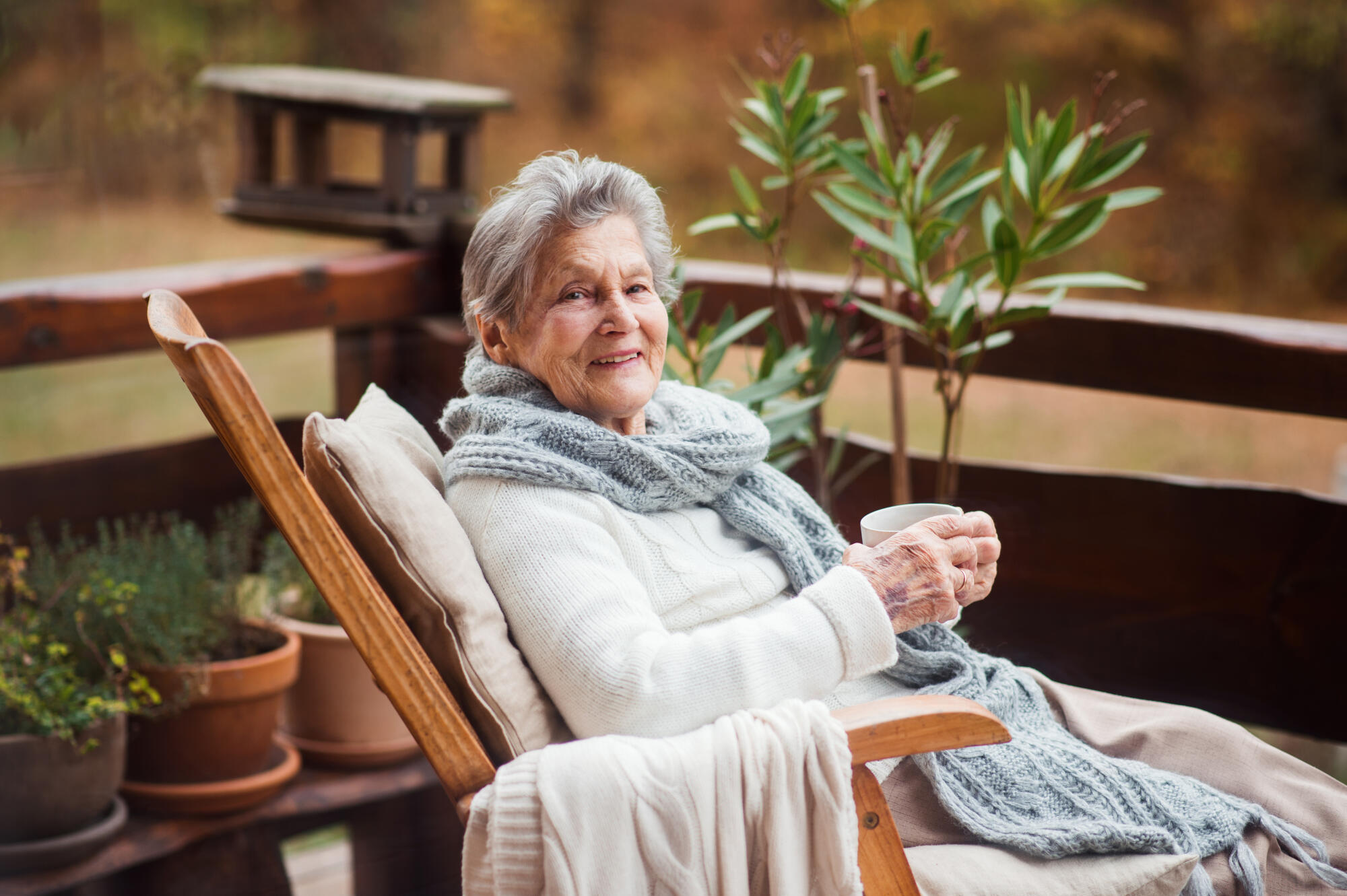 An,Elderly,Woman,With,A,Cup,Sitting,Outdoors,On,A An,Elderly,Woman,With,A,Cup,Sitting,Outdoors,On,A