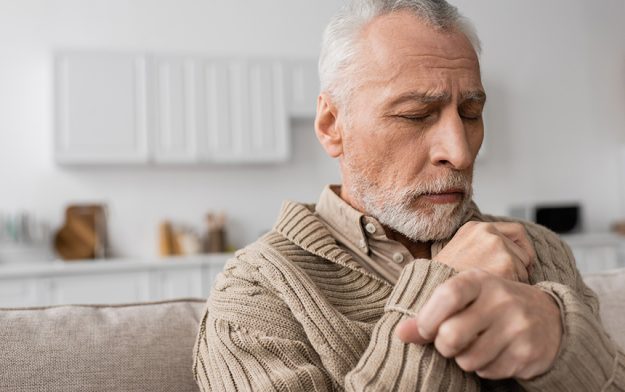 Depressed senior man parkinson disease sitting closed eyes home