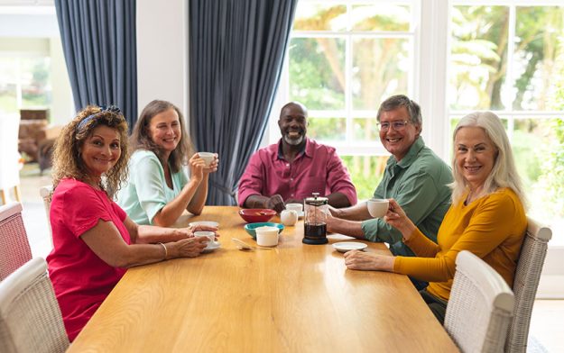 Portrait smiling multiracial senior female male friends having coffee together Portrait smiling multiracial senior female male friends having coffee together