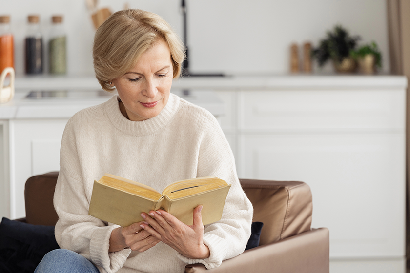 calm mature woman reading paper book