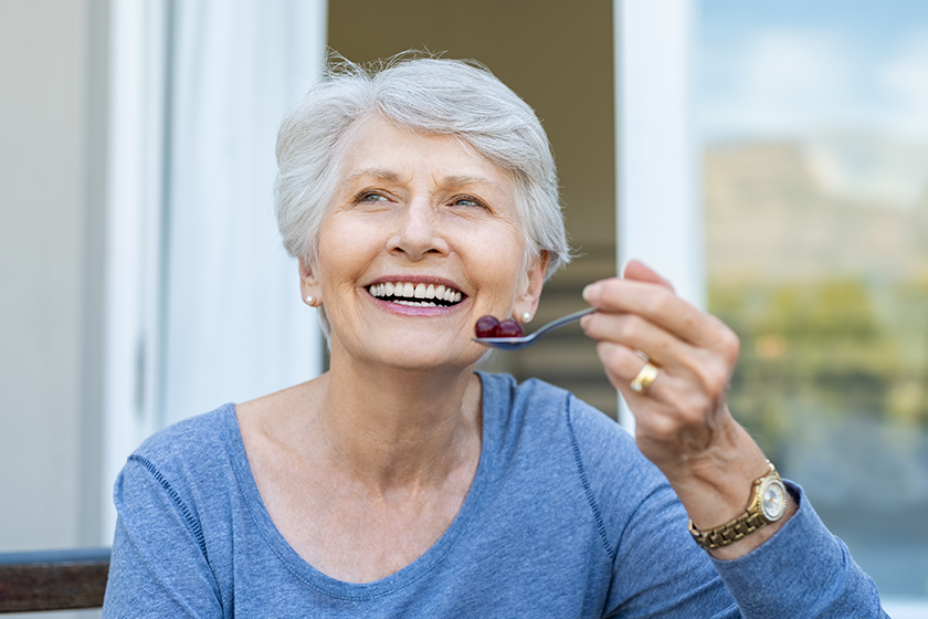 cheerful senior woman holding red grapes cheerful senior woman holding red grapes