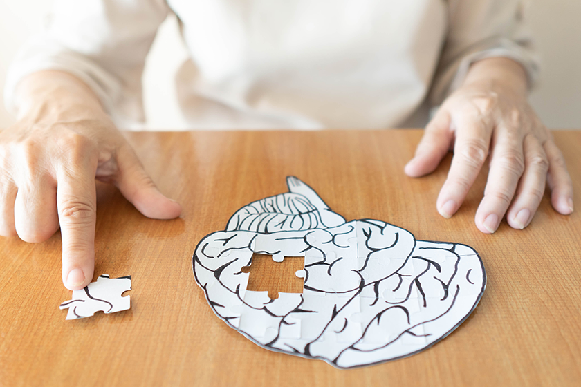 elderly woman hands putting missing white jigsaw puzzle