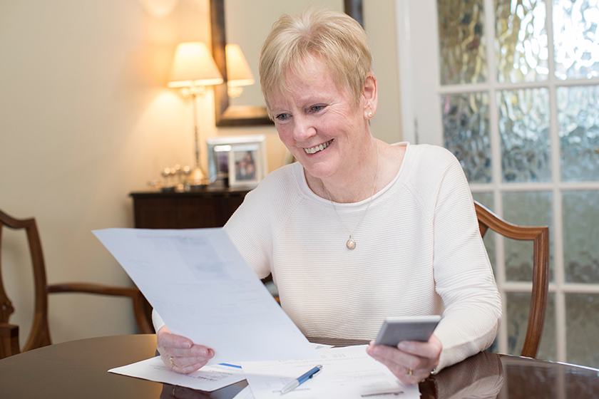 happy senior woman reviewing domestic finances
