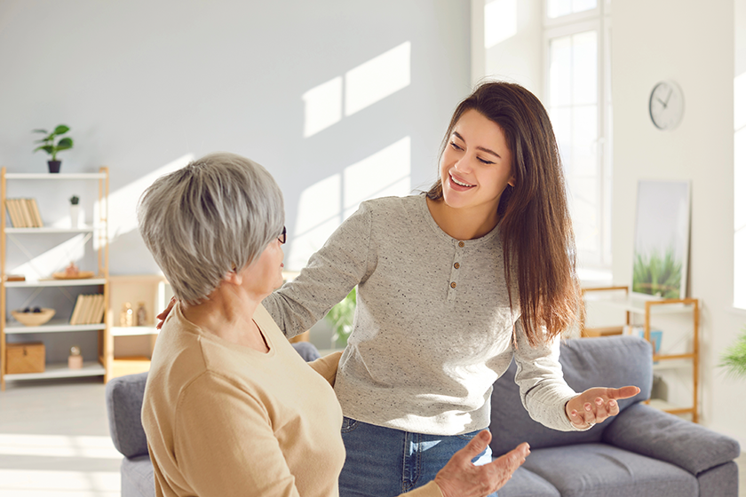 happy smiling adult daughter hugging her senior gray haired mother