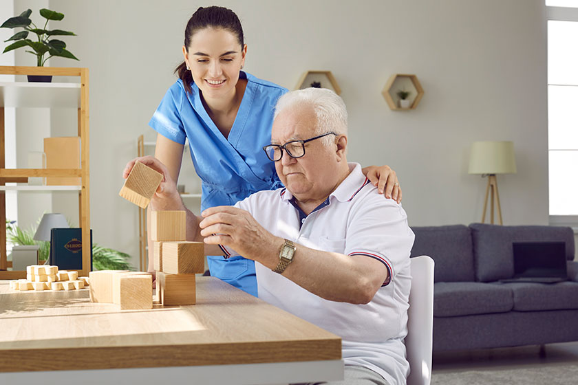 Helpful nurse playing games old male patient senior man cognitive Helpful nurse playing games old male patient senior man cognitive