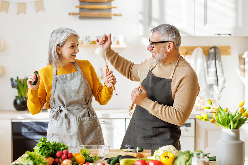 joyful elderly couple have fun dancing and singing while cooking joyful elderly couple have fun dancing and singing while cooking