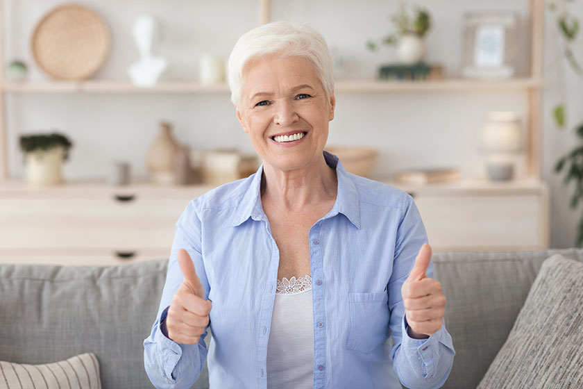 Life insurance for retirement happy senior lady showing thumb up at camera