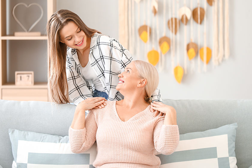 Mature woman and her adult daughter spending time together at home