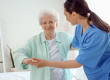 physical therapist helping senior woman bedroom