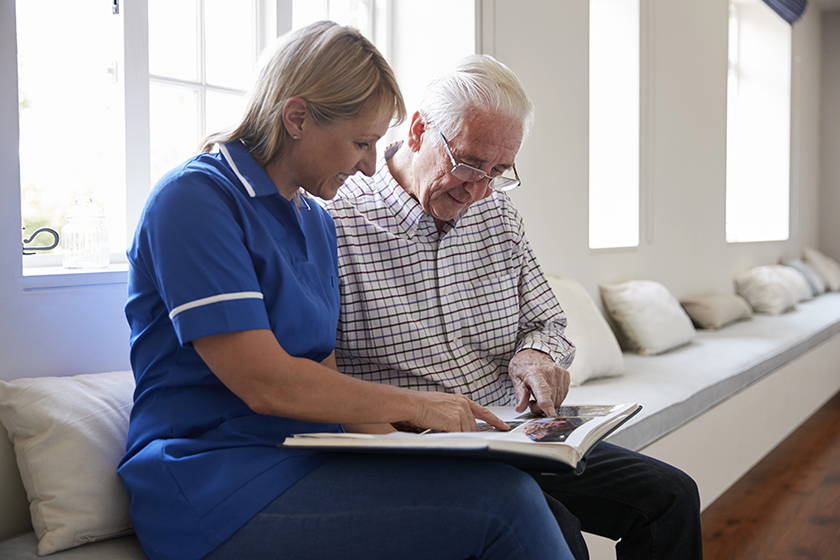 senior man sitting looking at photo album