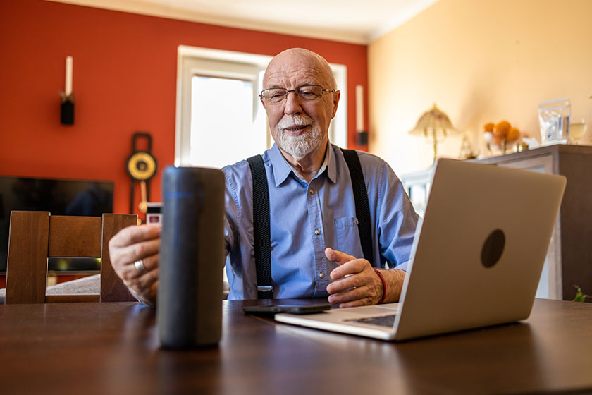 Senior man using virtual assistant home