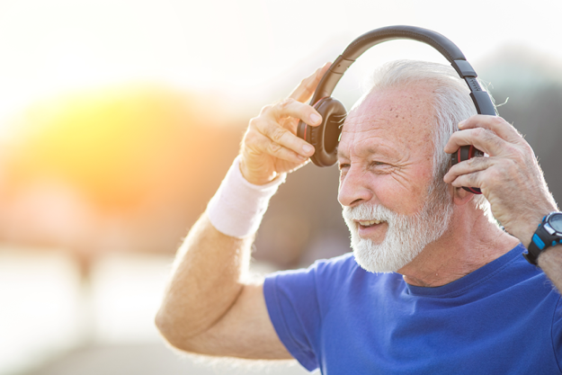 senior smiling man beard sportswear puts headphones