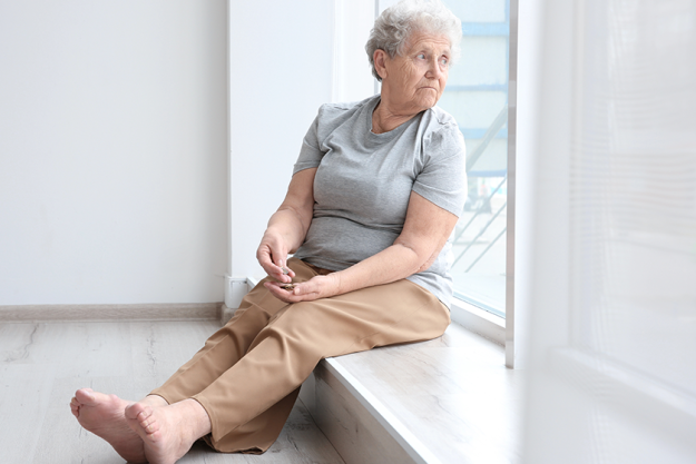 senior woman counting coins while sitting