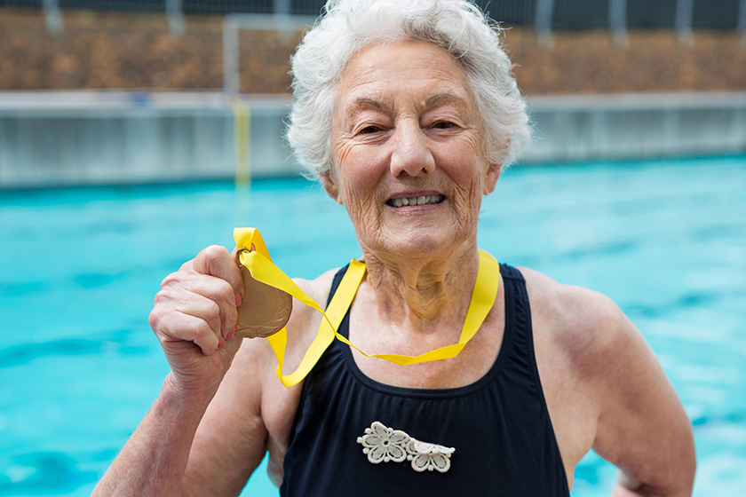 senior woman showing gold medal