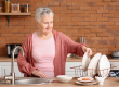 senior woman washing dishes in kitchen