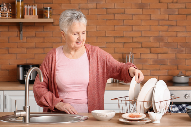 senior woman washing dishes in kitchen senior woman washing dishes in kitchen