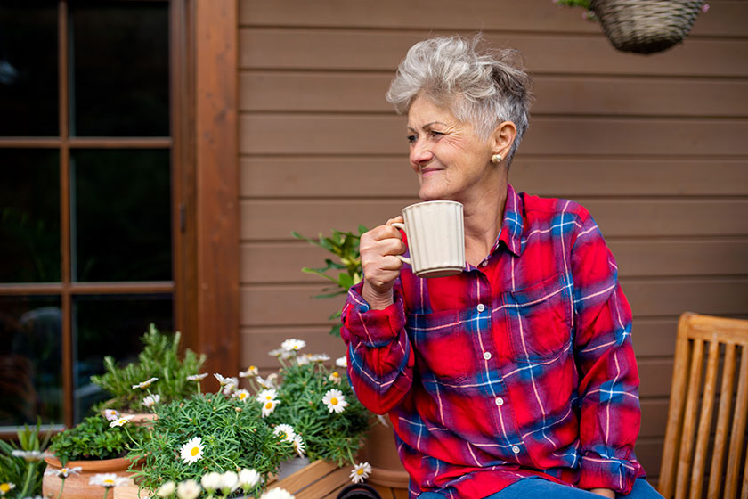 Senior woman with coffee sitting on terrace in summer resting Senior woman with coffee sitting on terrace in summer resting