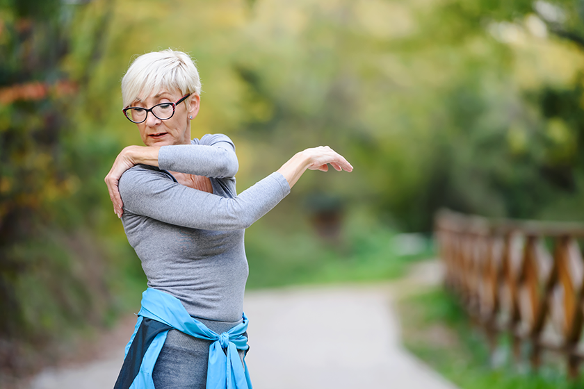 smiling senior woman stretching jogging smiling senior woman stretching jogging