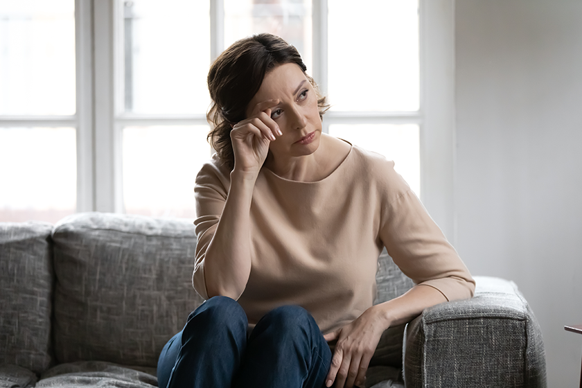 thoughtful mature woman touching forehead