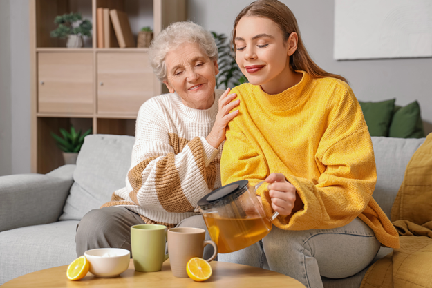 young woman her grandmother pouring tea