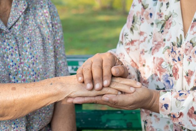 Caregiver holding hands Asian senior or elderly old lady woman p Caregiver holding hands Asian senior or elderly old lady woman p
