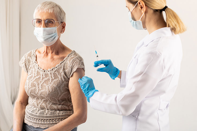 Médecin administrant un vaccin à un patient âgé dans un cadre médical professionnel