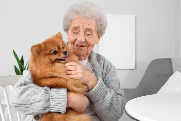 senior woman hugging pomeranian dog