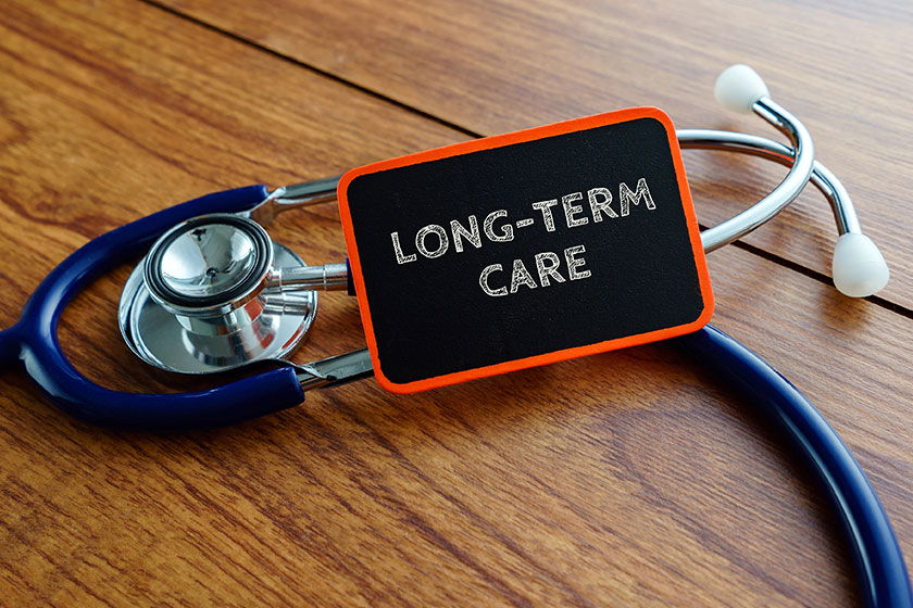 Word long term care with stethoscope on wooden table