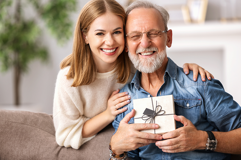 cheerful young woman hugging senior man