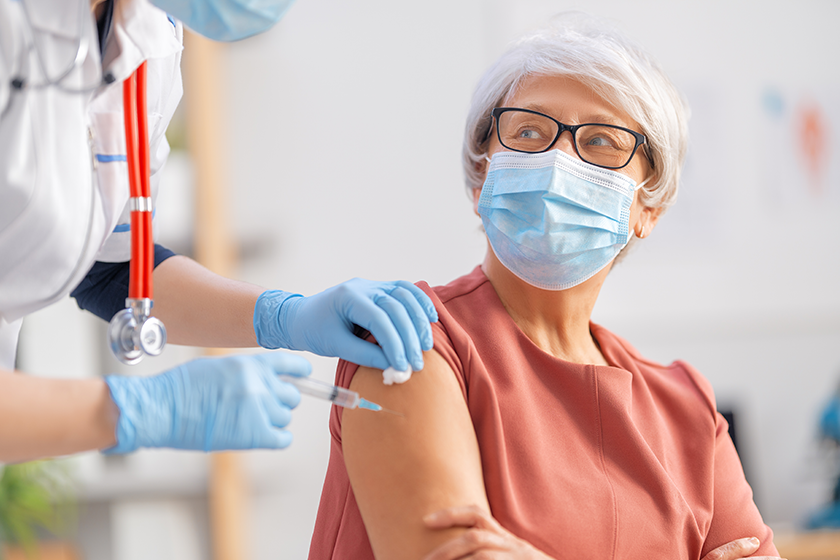 doctor giving senior woman vaccination