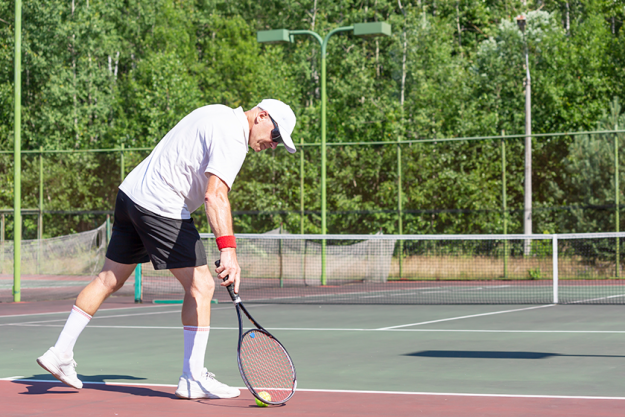 elderly man good physical shape plays tennis