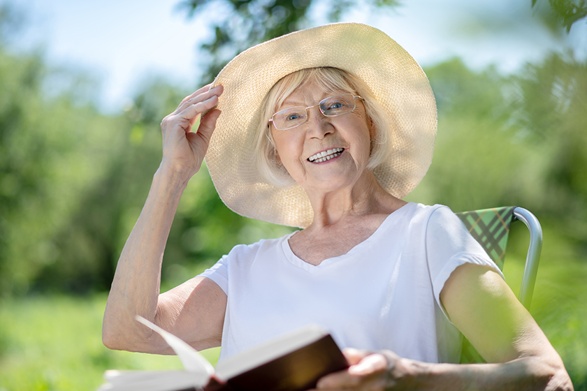 joyful woman reading a book in the garden