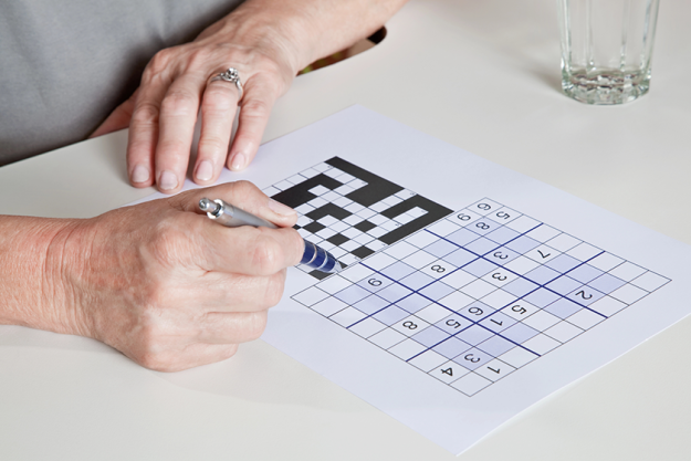mature woman playing sudoku puzzle mature woman playing sudoku puzzle