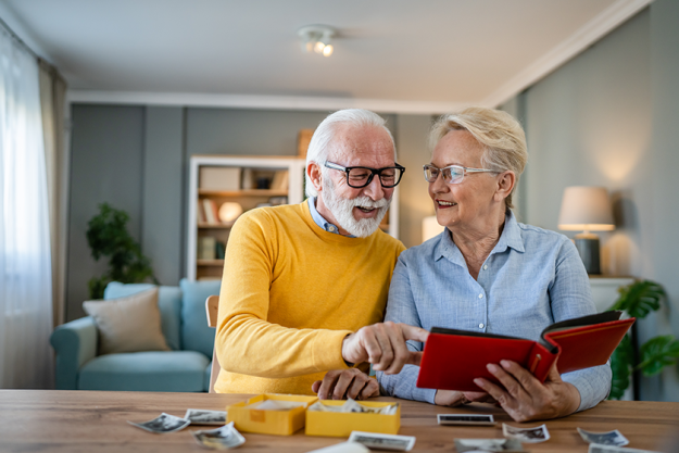senior couple man woman husband wife looking family photos