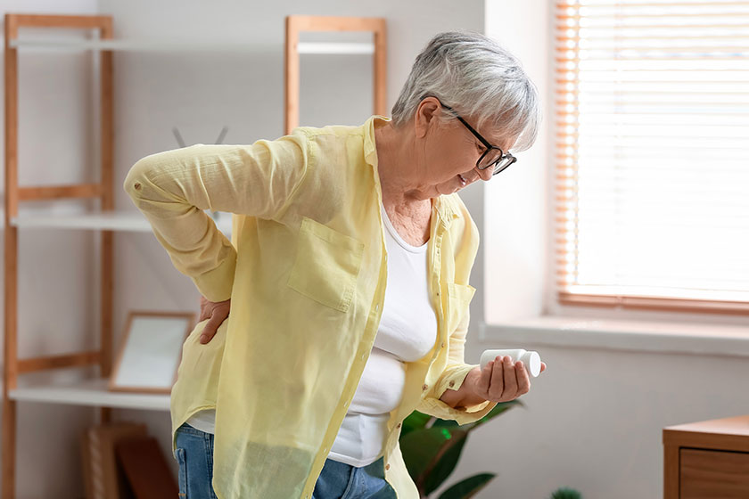 senior woman pills suffering back pain home
