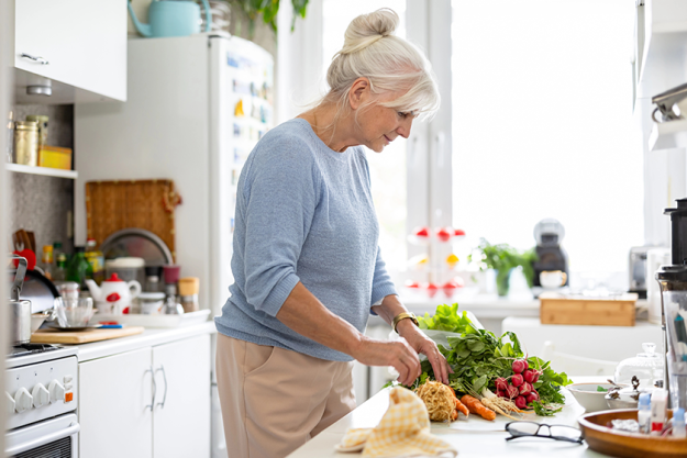 senior woman preparing vegetable salad