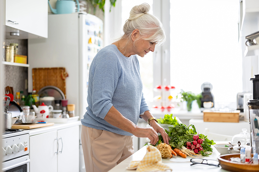 senior woman preparing vegetable salad