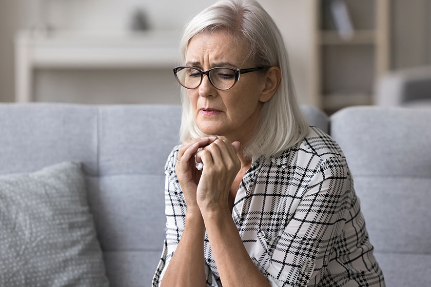 Upset stressed mature woman glasses sitting alone couch home suffering Upset stressed mature woman glasses sitting alone couch home suffering