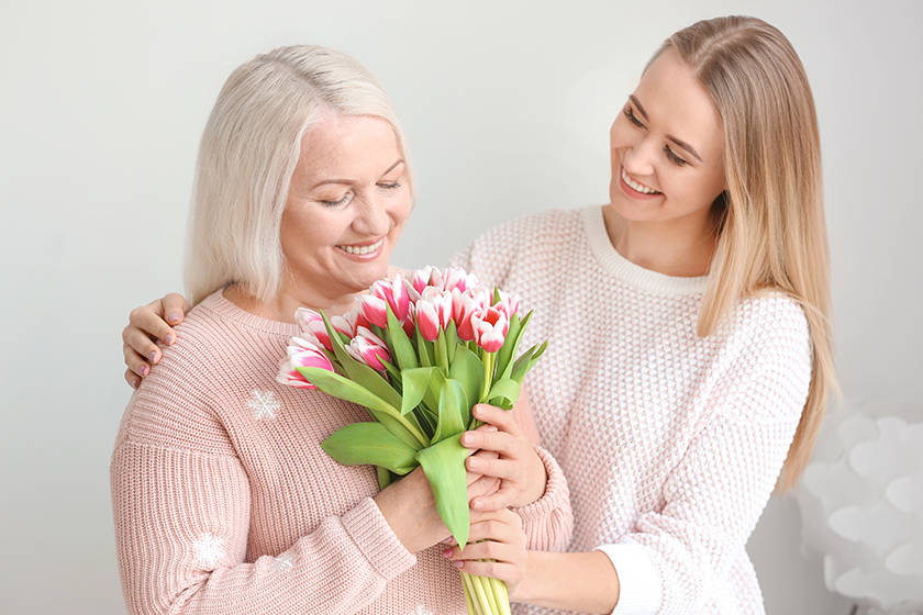 young daughter and mother with bouquet of flowers