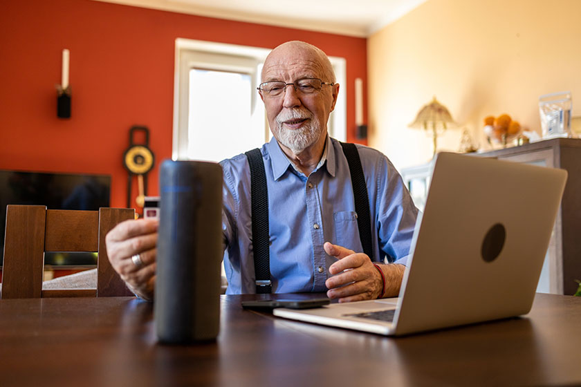 Senior man using virtual assistant home