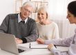 Older couple considering new home purchase looking at laptop