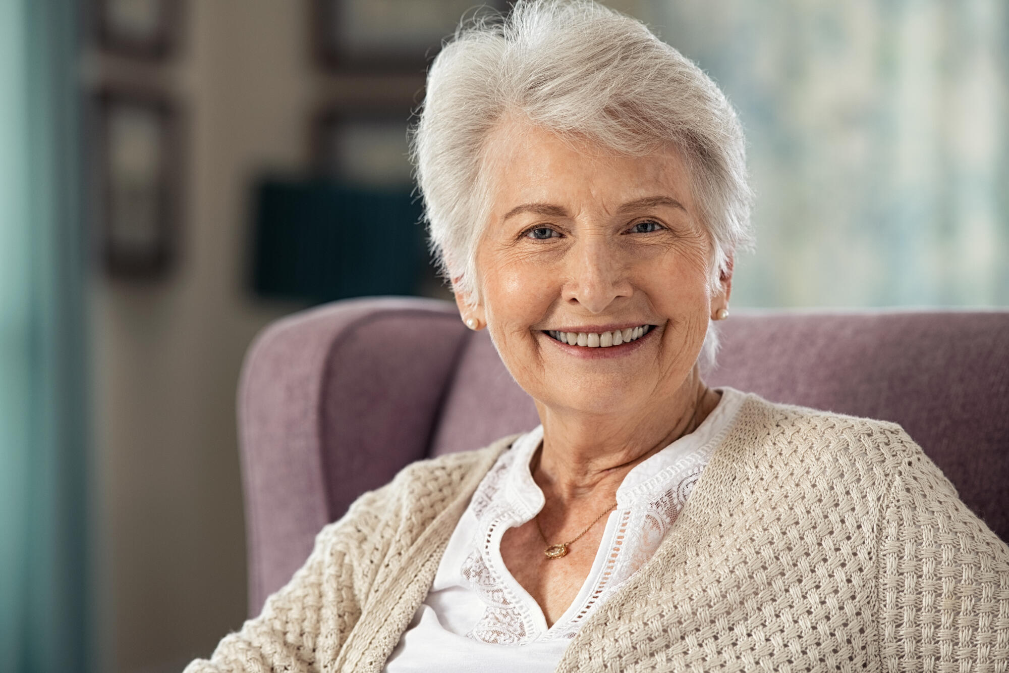 Portrait,Of,Joyful,Old,Woman,Sitting,On,Armchair,Looking,At