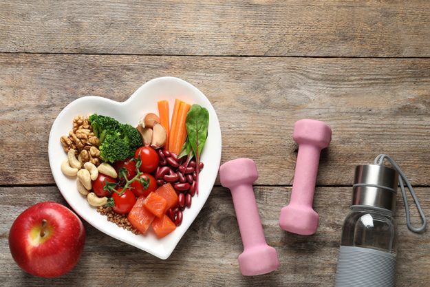 Flat lay composition with plate of heart healthy diet products and space for text on Flat lay composition with plate of heart healthy diet products and space for text on