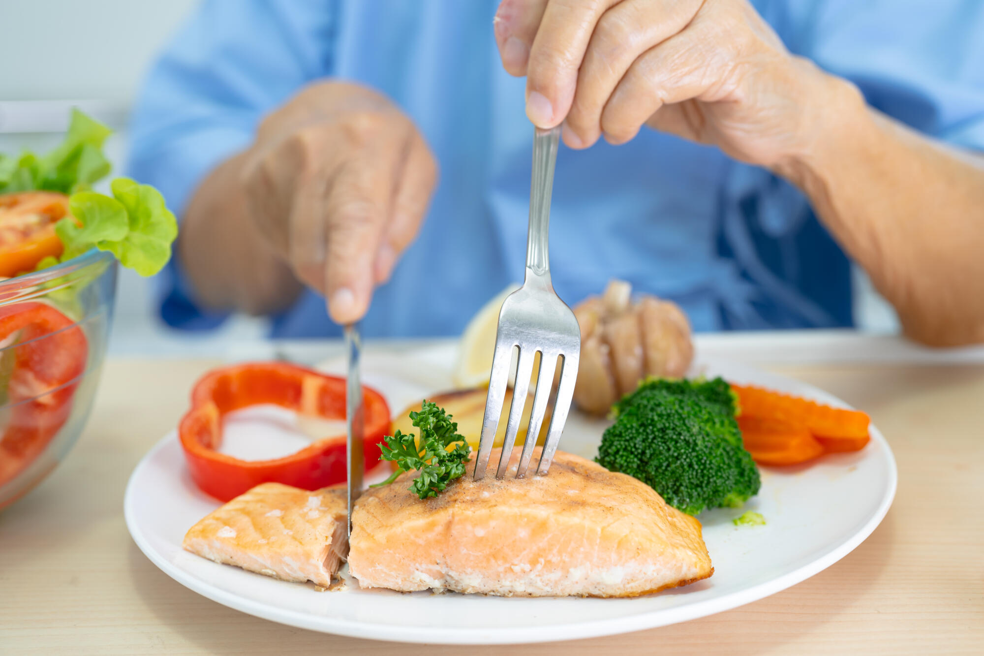 Asian senior woman patient eating Salmon steak breakfast with ve