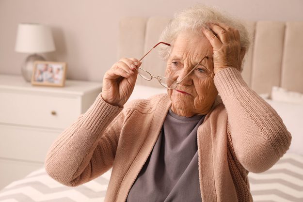 Senior woman headache bedroom home