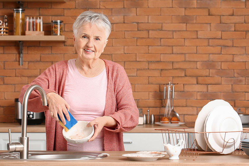 Senior woman washing dishes in kitchen