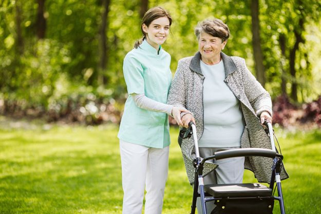 Young female trainee with patient in the nursing home