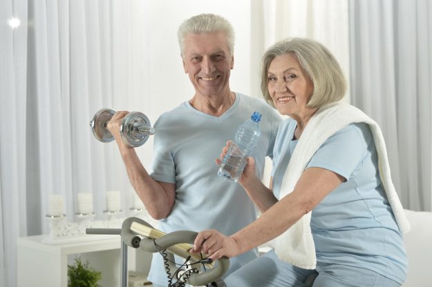 Portrait of happy sporty senior couple exercising